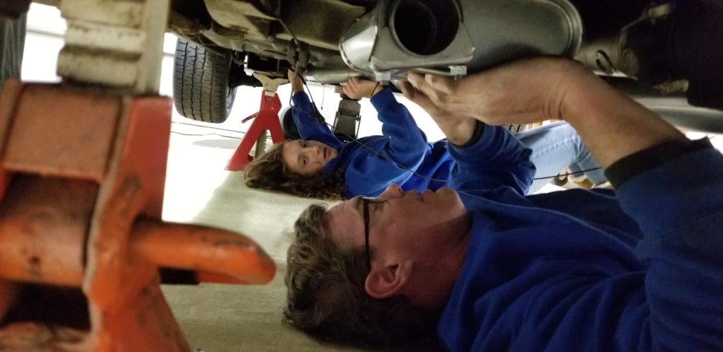 father and daughter working on a car