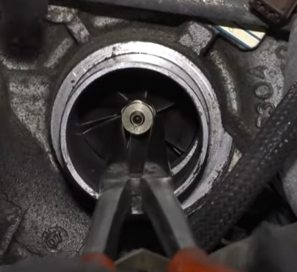 Testing the turbo's compressor wheel with needle nose pliers