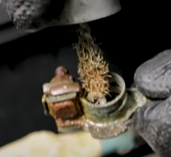 Cleaning the inner portion of the battery terminal connector with a metal brush