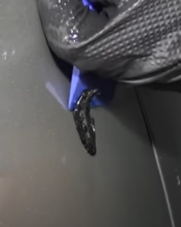Scraping glue off of car paint after using a dent puller tool
