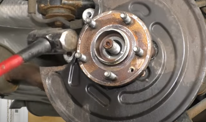 Tapping a stuck wheel hub with a hammer