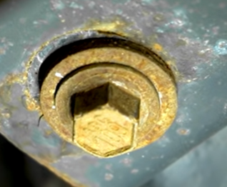 Suspension bolt that has shifted and has its old position marked by the stain of the washer