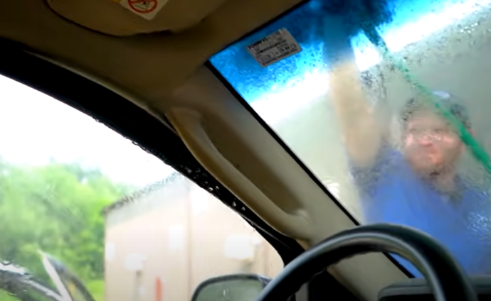 Spraying water onto a car with a garden hose