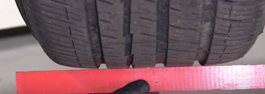 Ruler showing how the rear tires have worn to look flat and almost concaved at the center