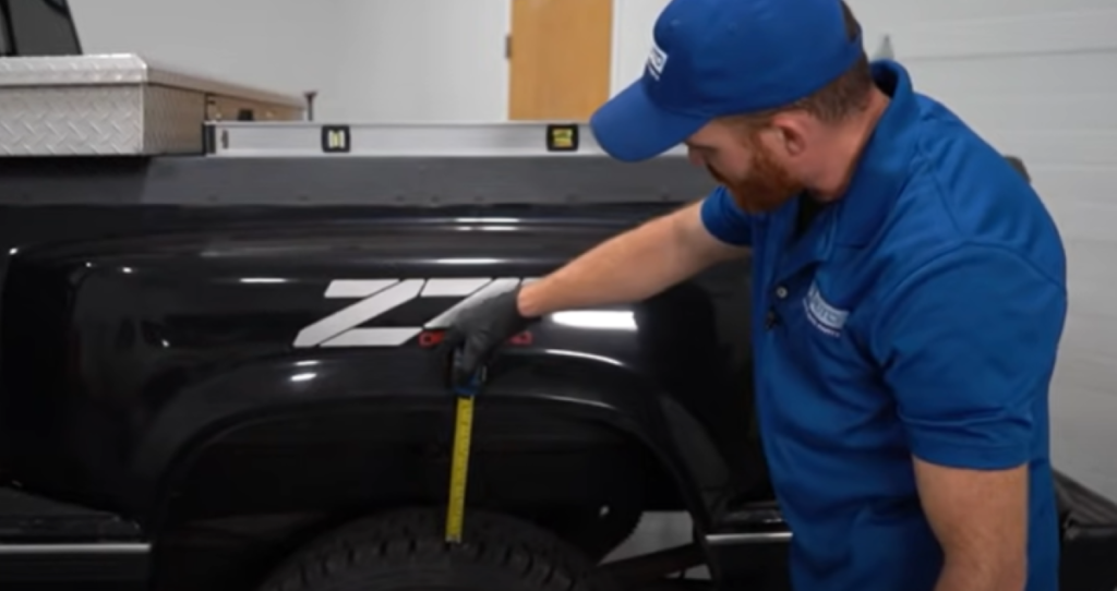 Measuring a truck's rake with a leveler and tape measurer