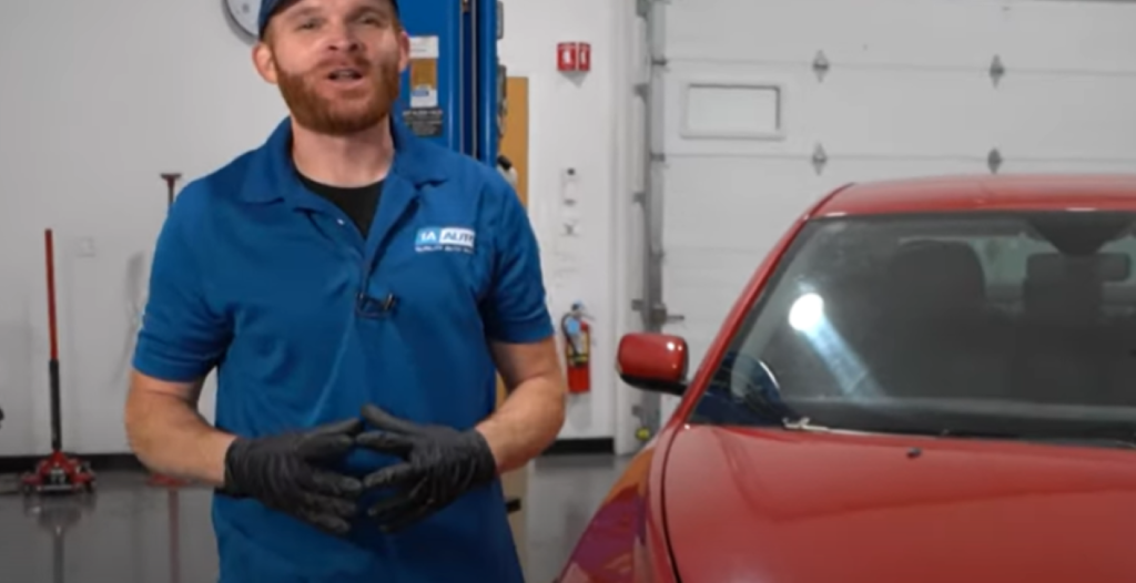 1A Auto mechanic standing in front of a 2nd gen Volvo S40 and reviewing its common problems