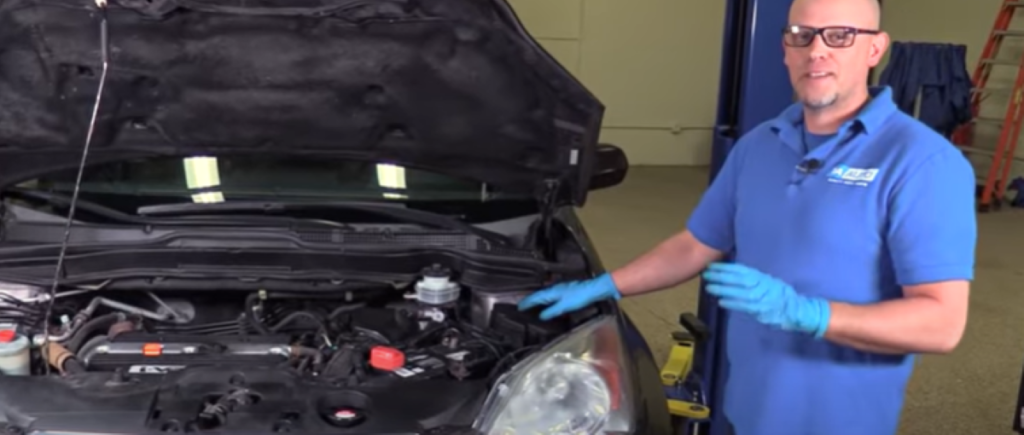 1A Auto mechanic reviewing how to check fuses without removing them by using a test light