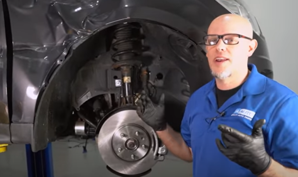 Mechanic reviewing struts, which are a common cause for a car to be bouncing up and down excessively