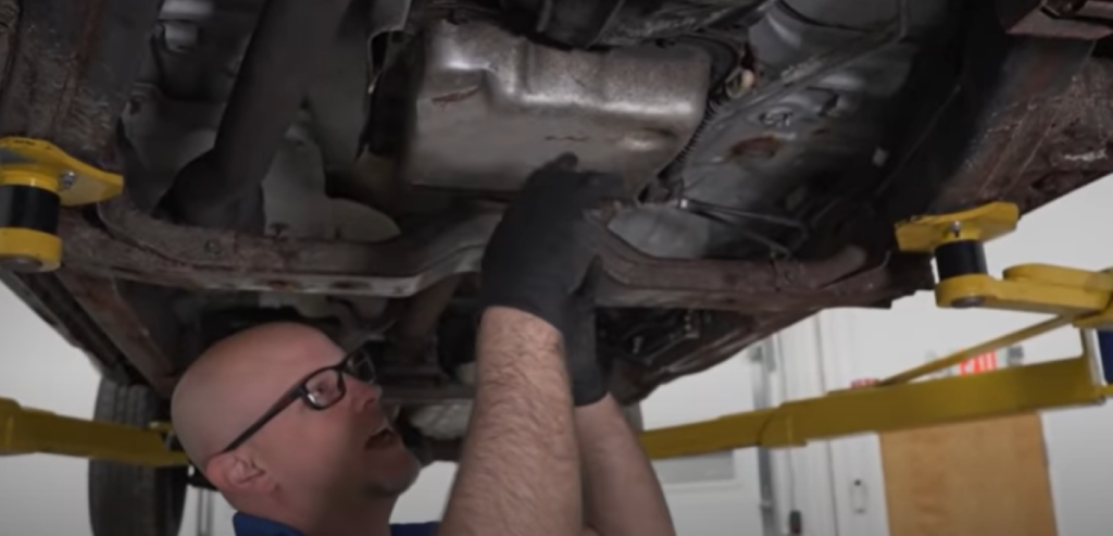 Mechanic removing a transmission oil pan due to a transmission shudder