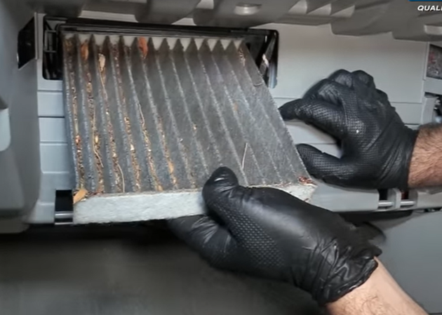 Mechanic removing a dirty cabin air filter