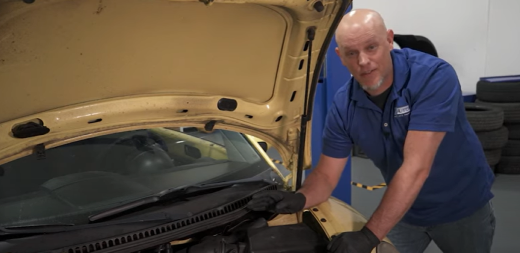 Mechanic under the hood of a 1st gen 1998 to 2010 Volkswagen Beetle reviewing its top 5 common problems