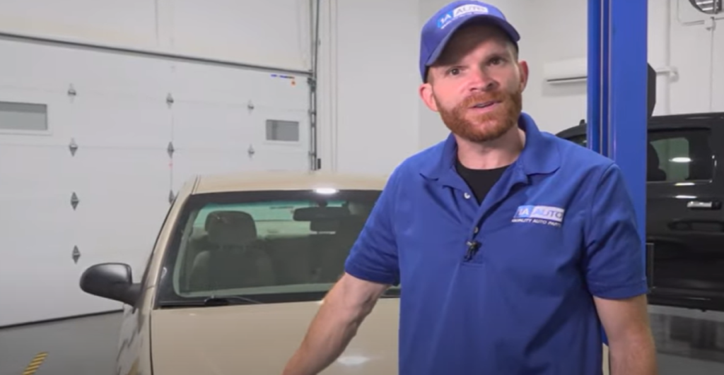 1A Auto mechanic standing in front of a car and reviewing why it could smell like gas