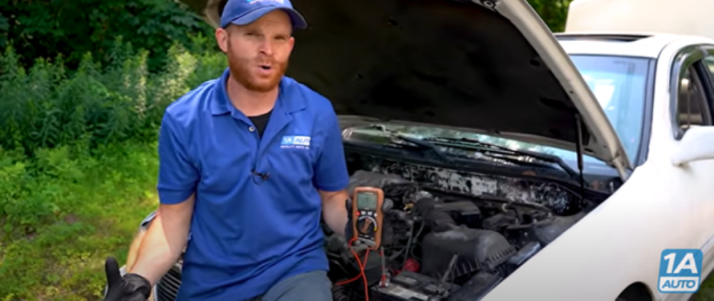 Mechanic standing next to a car reviewing if it can run without a battery