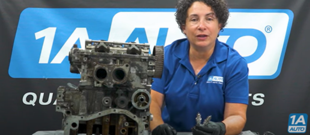 Mechanic next to a boxer engine explaining how worn spark plugs can cause engine sputtering
