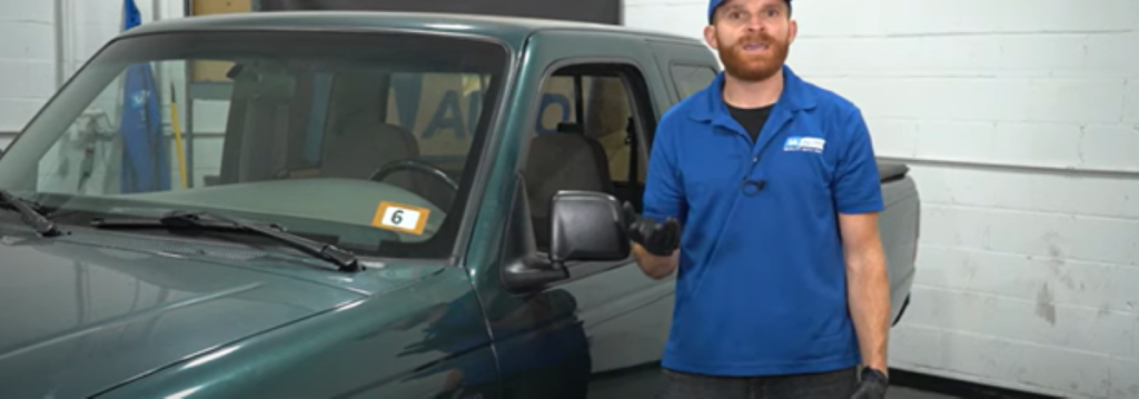 Mechanic standing next to a truck and reviewing why a wheel could be locking up while driving