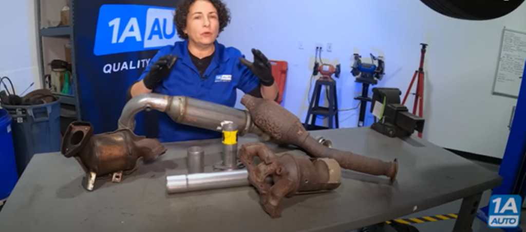 Mechanic standing before different types of catalytic converters