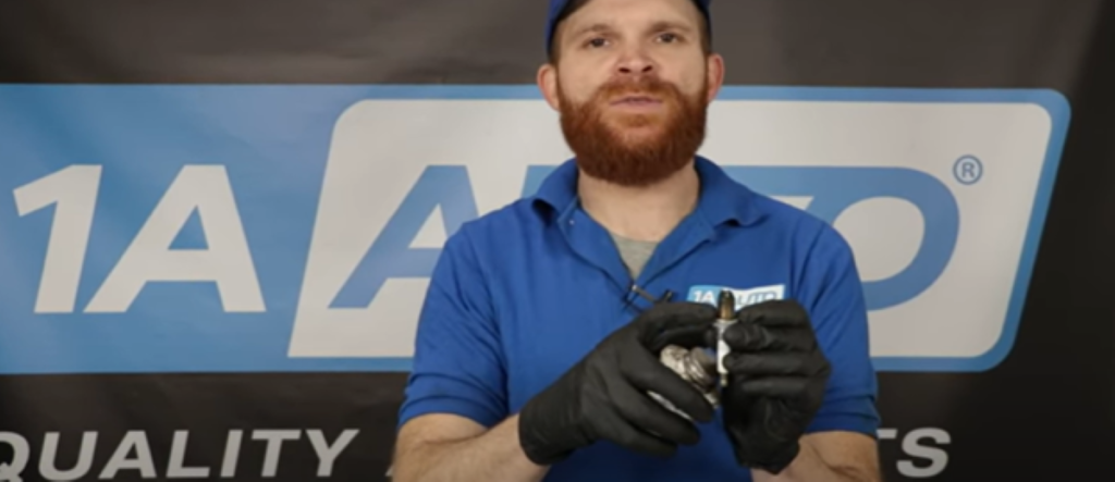 Mechanic holding a spark plug and reviewing what spark plugs do