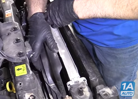 Mechanic removing a radiator fan from a 2008 to 2012 Ford Escape