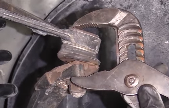 Checking an upper ball joint for play by squeezing it with pliers